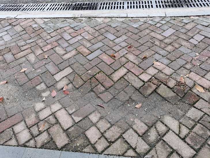 人行道坑洼不平，下雨时积水